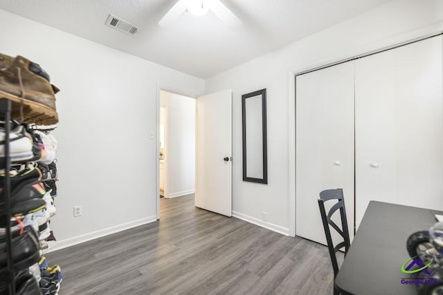 home office with wood finished floors, ceiling fan, and baseboards