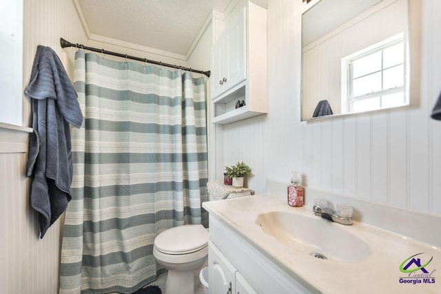 full bath featuring toilet, vanity, a textured ceiling, ornamental molding, and curtained shower