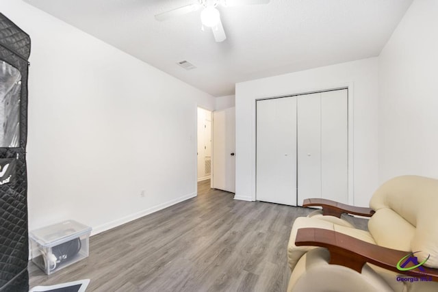 sitting room featuring wood finished floors, a ceiling fan, and baseboards
