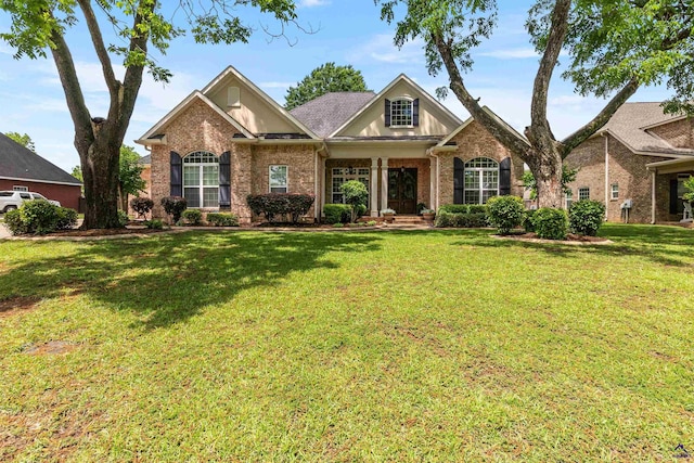 view of front of home with a front yard and brick siding