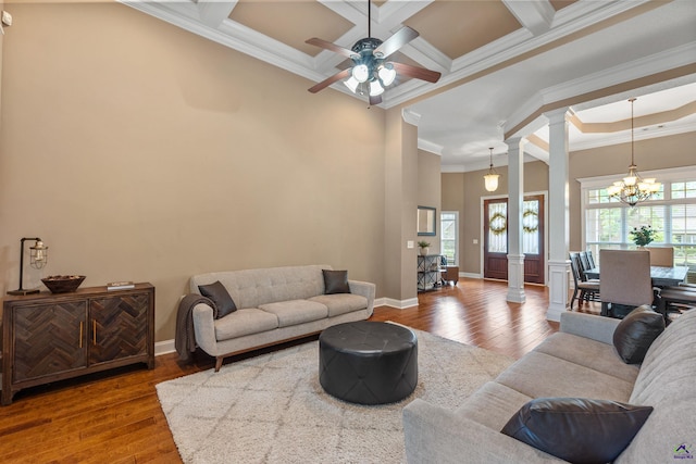 living room featuring ornate columns, ornamental molding, hardwood / wood-style floors, a chandelier, and a ceiling fan