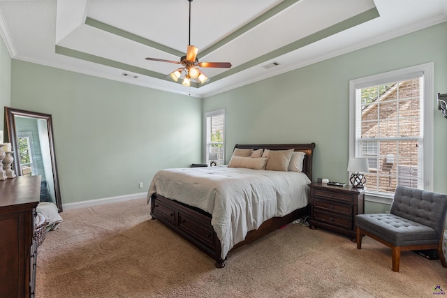 bedroom featuring a raised ceiling, light colored carpet, multiple windows, ornamental molding, and baseboards