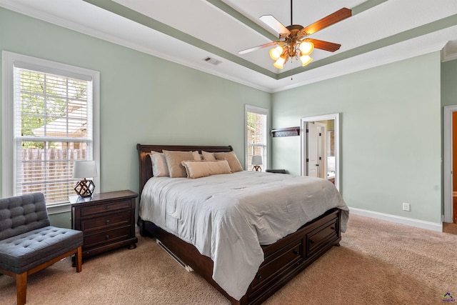 bedroom with light colored carpet, ornamental molding, baseboards, a raised ceiling, and ceiling fan