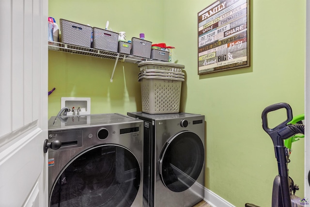 clothes washing area with washing machine and dryer and baseboards