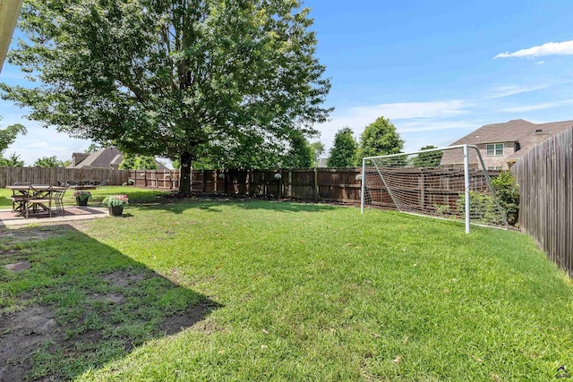 fenced backyard featuring a patio area and an area for soccer