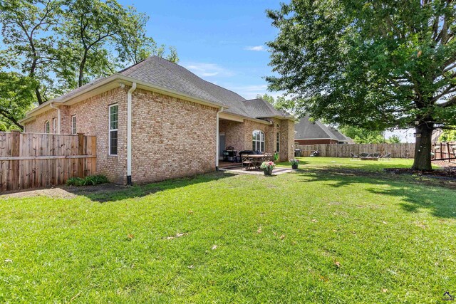 back of property featuring brick siding, a patio, and a shingled roof