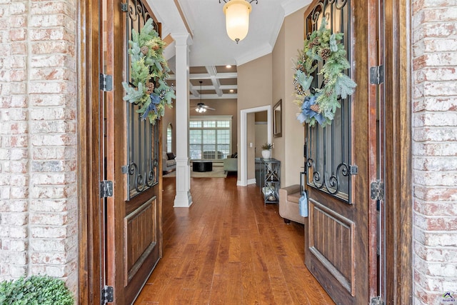 foyer entrance with coffered ceiling, ornate columns, ornamental molding, hardwood / wood-style flooring, and beamed ceiling