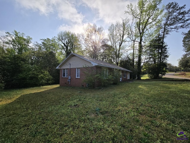 view of property exterior with a lawn and brick siding
