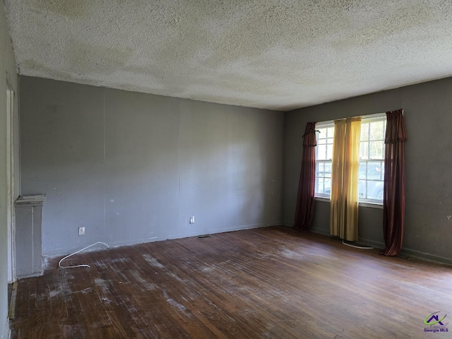 spare room with wood finished floors and a textured ceiling