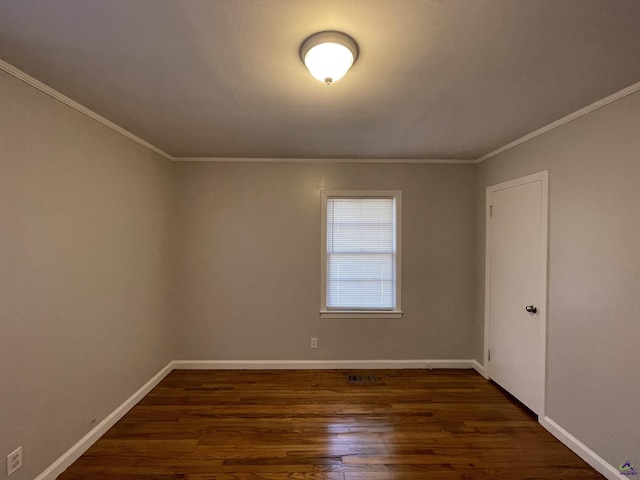 unfurnished room featuring dark wood-style flooring, ornamental molding, and baseboards