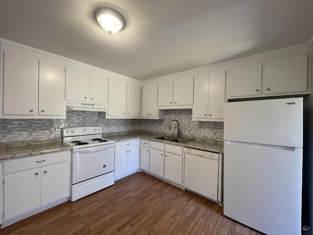 kitchen with white appliances, a sink, under cabinet range hood, dark wood-style floors, and backsplash