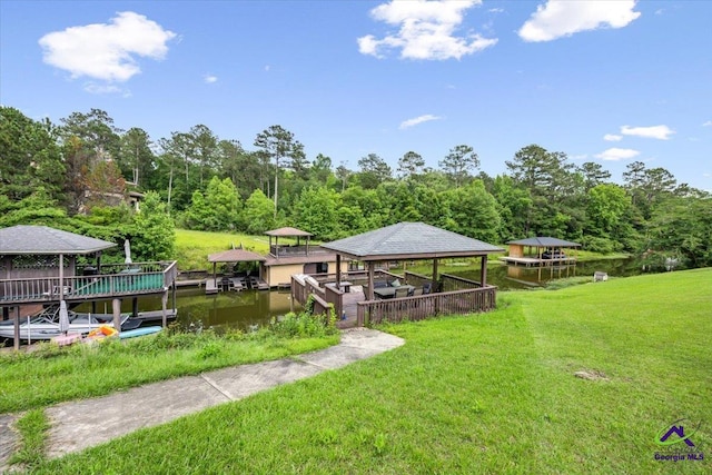 dock featuring a gazebo, a yard, a water view, and a forest view
