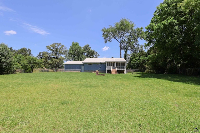 view of grassy yard with a sunroom