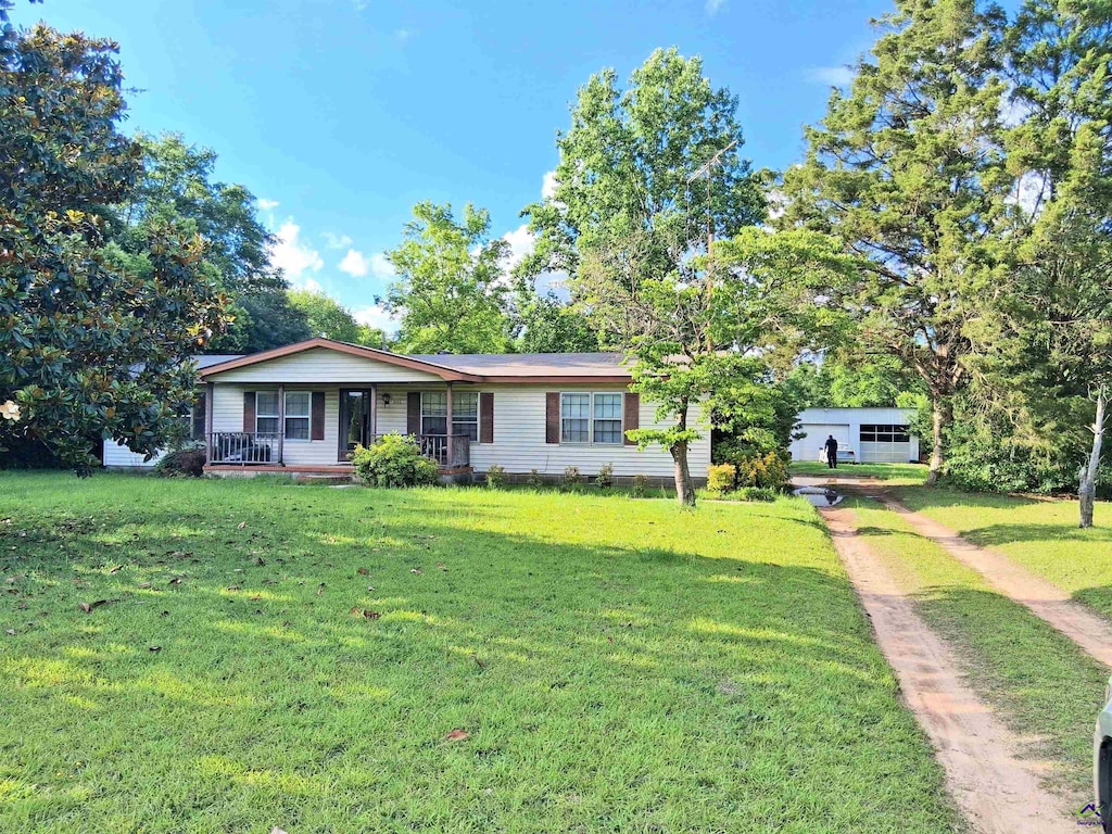 1555 Flanagan Dr, Macon, GA 31216 - ranch-style home featuring a porch, a front yard, and dirt driveway