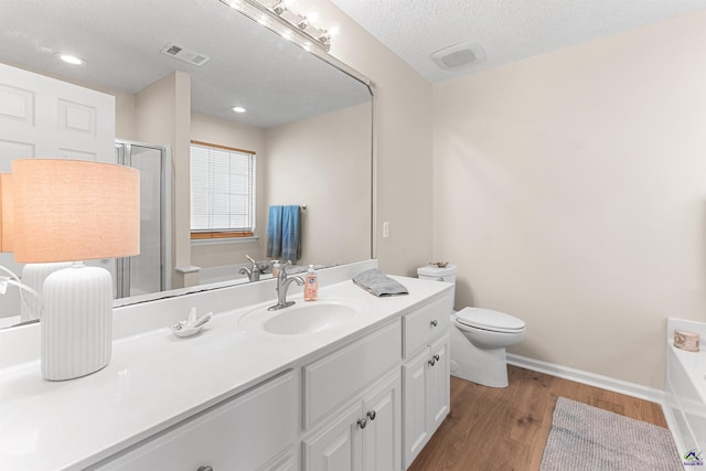 full bathroom featuring wood finished floors, vanity, a bath, toilet, and a shower stall