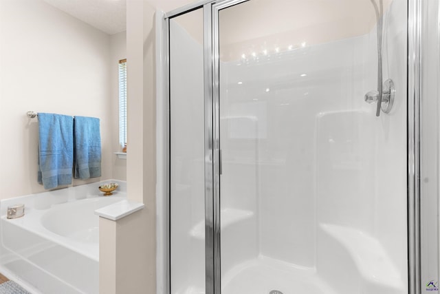 full bath featuring a shower stall and a garden tub