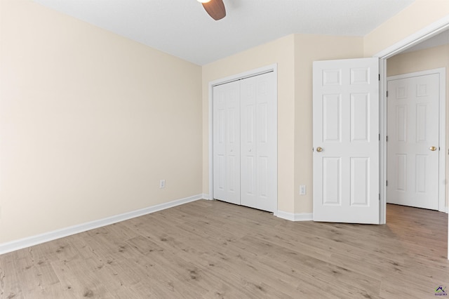 unfurnished bedroom featuring light wood-style floors, baseboards, a closet, and ceiling fan