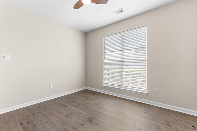 unfurnished room with ceiling fan, baseboards, healthy amount of natural light, and a textured ceiling