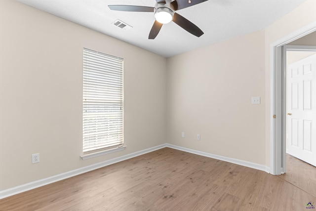 unfurnished room with ceiling fan, light wood-style floors, and baseboards
