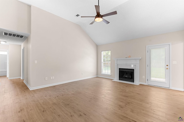 unfurnished living room with ceiling fan, light wood-style floors, a fireplace, baseboards, and high vaulted ceiling