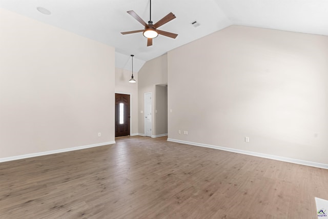 unfurnished living room with ceiling fan, high vaulted ceiling, baseboards, and light wood-type flooring