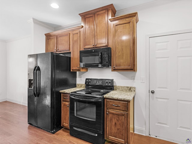 427 Oscar Ct, Mcdonough, GA 30252 - kitchen featuring black appliances, crown molding, light stone counters, light wood-type flooring, and baseboards