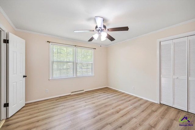 3015 Clairmont Ave, Macon, GA 31204 - unfurnished bedroom featuring light wood-style flooring, crown molding, a closet, baseboards, and baseboard heating