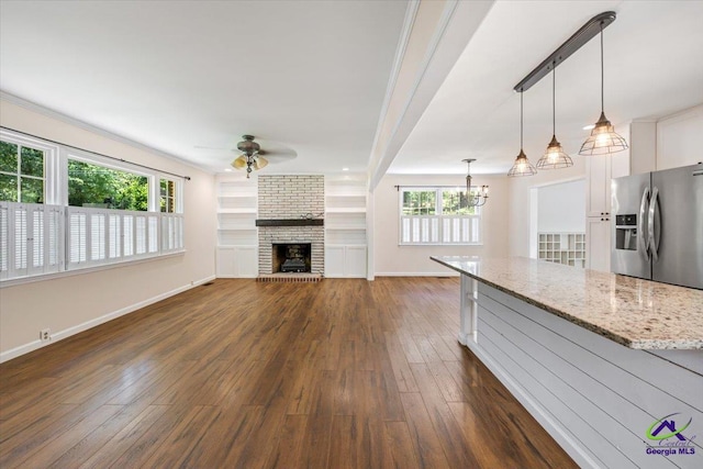 3015 Clairmont Ave, Macon, GA 31204 - unfurnished living room with a ceiling fan, dark wood finished floors, baseboards, a brick fireplace, and a chandelier