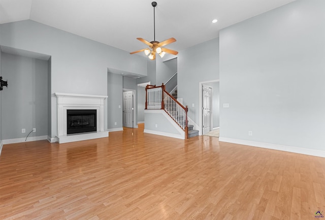 210 Vining Way, Byron, GA 31008 - unfurnished living room with stairs, light wood-style floors, ceiling fan, a fireplace with raised hearth, and baseboards