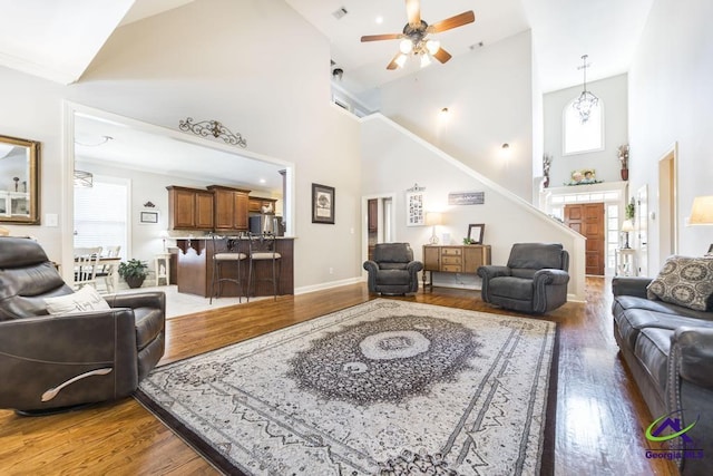 215 Wilson Creek Bnd, Bonaire, GA 31005 - living room with high vaulted ceiling, wood finished floors, ceiling fan, stairs, and baseboards