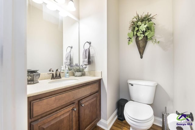 215 Wilson Creek Bnd, Bonaire, GA 31005 - bathroom featuring vanity, toilet, baseboards, and wood finished floors