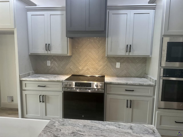 86 Camden Way, Hawkinsville, GA 31036 - kitchen with stainless steel appliances, decorative backsplash, and light stone counters