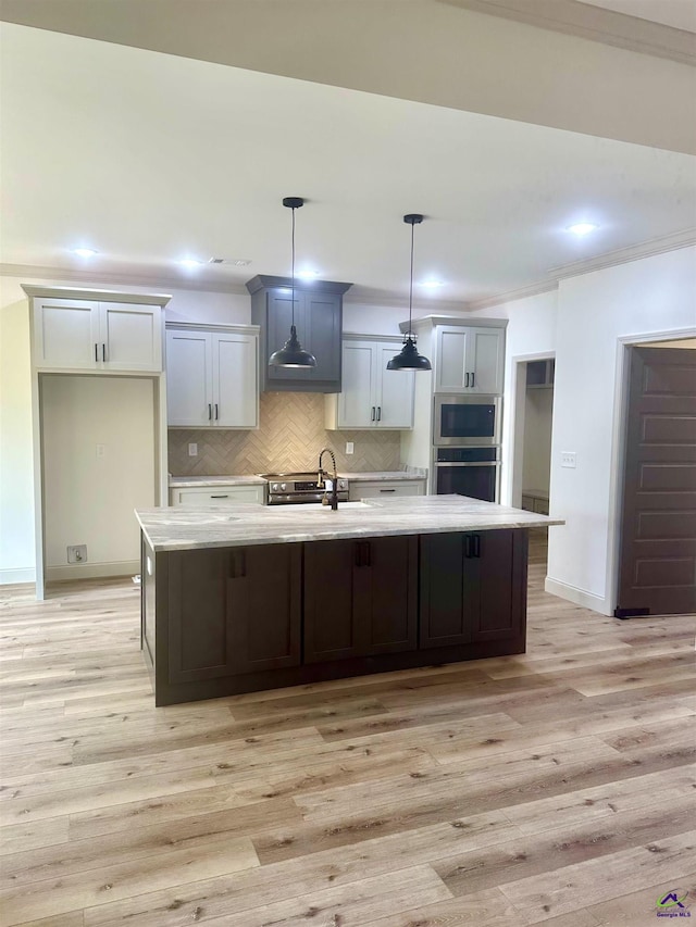 86 Camden Way, Hawkinsville, GA 31036 - kitchen featuring stainless steel appliances, a sink, light countertops, a large island with sink, and tasteful backsplash