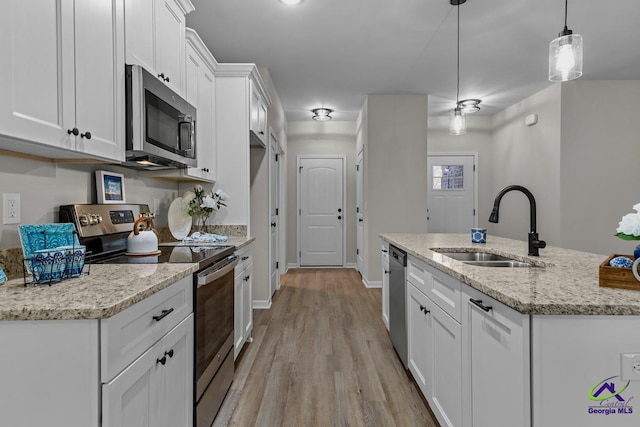 3054 Cellar Ln, Perry, GA 31069 - kitchen featuring appliances with stainless steel finishes, a sink, white cabinetry, light wood finished floors, and a kitchen island with sink