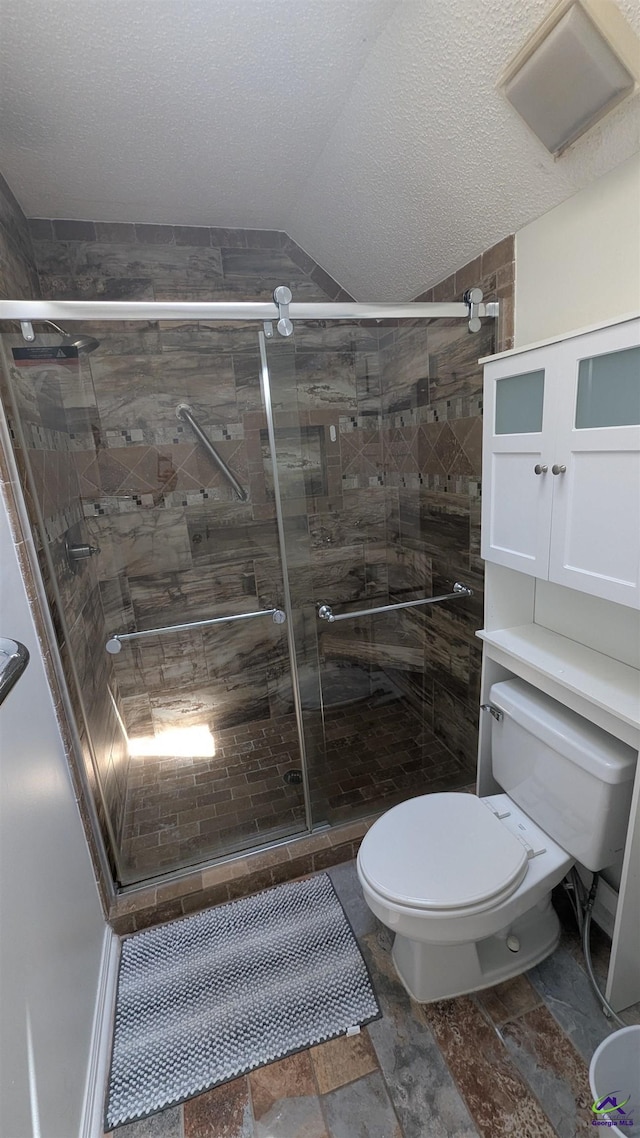 107 Whitney Ct, Warner Robins, GA 31088 - full bath featuring toilet, lofted ceiling, a shower stall, a textured ceiling, and stone finish floors