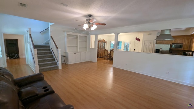 107 Whitney Ct, Warner Robins, GA 31088 - living room with light wood-type flooring, decorative columns, ceiling fan, stairway, and baseboards