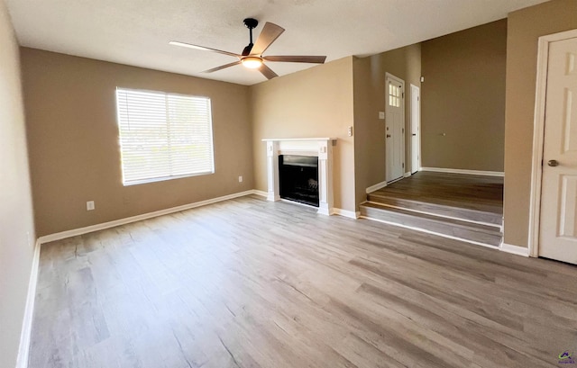 109 Stoneridge Dr, Warner Robins, GA 31088 - unfurnished living room with ceiling fan, wood finished floors, a fireplace, and baseboards