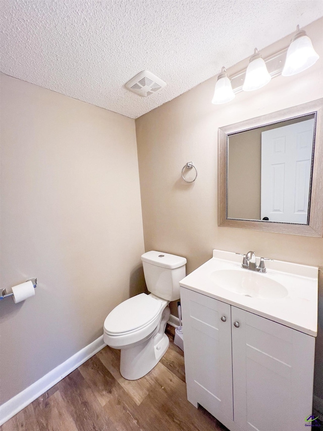 109 Stoneridge Dr, Warner Robins, GA 31088 - bathroom with wood finished floors, toilet, vanity, a textured ceiling, and baseboards