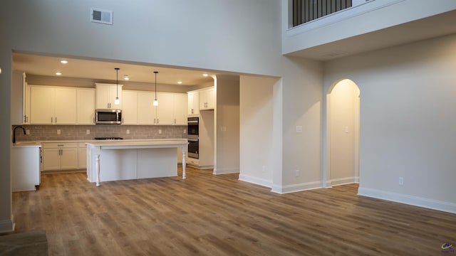 303 Garnet Dr, Bonaire, GA 31005 - kitchen featuring stainless steel appliances, arched walkways, a towering ceiling, recessed lighting, and baseboards