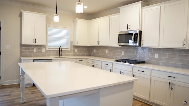 303 Garnet Dr, Bonaire, GA 31005 - kitchen featuring appliances with stainless steel finishes, a sink, tasteful backsplash, white cabinets, and ornamental molding