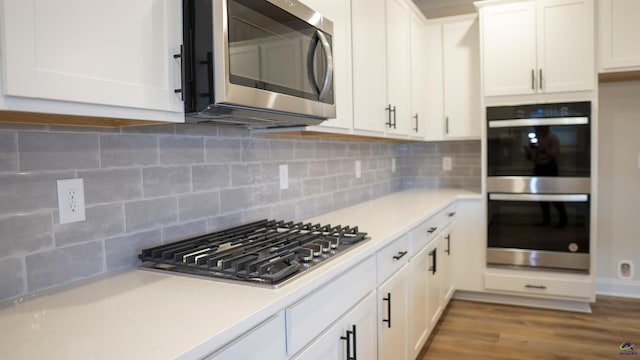 303 Garnet Dr, Bonaire, GA 31005 - kitchen with stainless steel appliances, light countertops, white cabinets, and decorative backsplash
