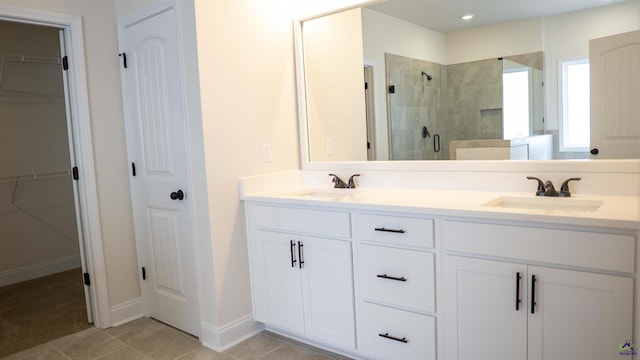 303 Garnet Dr, Bonaire, GA 31005 - full bathroom featuring a stall shower, double vanity, a spacious closet, and tile patterned flooring
