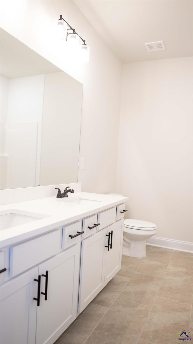 303 Garnet Dr, Bonaire, GA 31005 - bathroom featuring double vanity, toilet, and baseboards