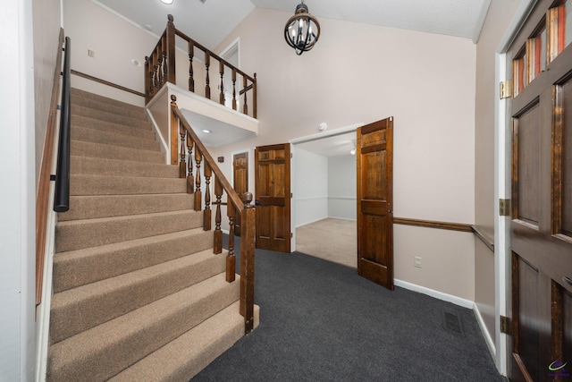 207 Oak Forest Ln, Warner Robins, GA 31088 - stairway featuring carpet, baseboards, vaulted ceiling, and a chandelier