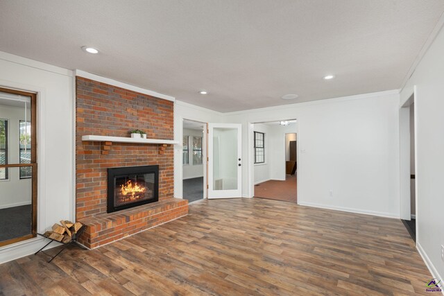 207 Oak Forest Ln, Warner Robins, GA 31088 - unfurnished living room with wood finished floors, baseboards, a fireplace, ornamental molding, and recessed lighting