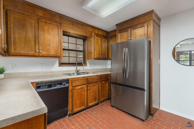207 Oak Forest Ln, Warner Robins, GA 31088 - kitchen with freestanding refrigerator, dishwasher, a sink, brown cabinets, and brick patterned flooring