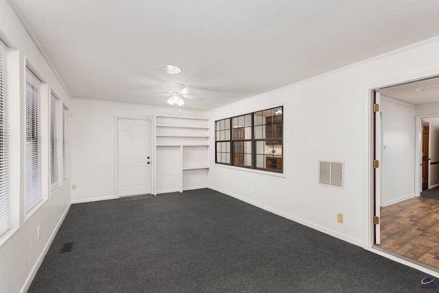 207 Oak Forest Ln, Warner Robins, GA 31088 - unfurnished room with ceiling fan, dark colored carpet, built in shelves, a textured ceiling, and baseboards