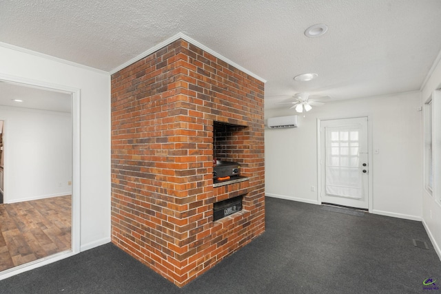 207 Oak Forest Ln, Warner Robins, GA 31088 - unfurnished living room featuring a wall mounted air conditioner, a textured ceiling, ceiling fan, baseboards, and crown molding