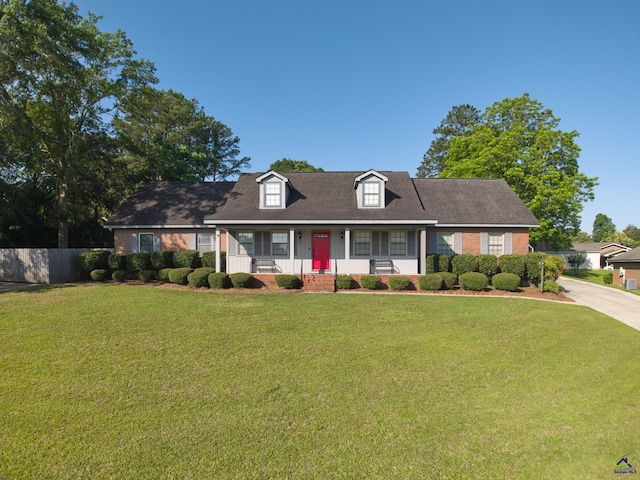 207 Oak Forest Ln, Warner Robins, GA 31088 - cape cod-style house featuring covered porch, driveway, roof with shingles, and brick siding