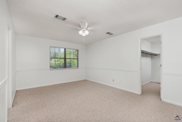 207 Oak Forest Ln, Warner Robins, GA 31088 - unfurnished bedroom with carpet flooring, a walk in closet, baseboards, a closet, and a ceiling fan